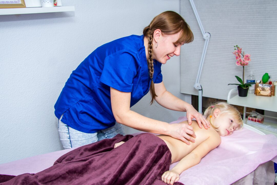 Oksana Marchenko masajes quiropractica pediatrica a niña tumbada en camilla